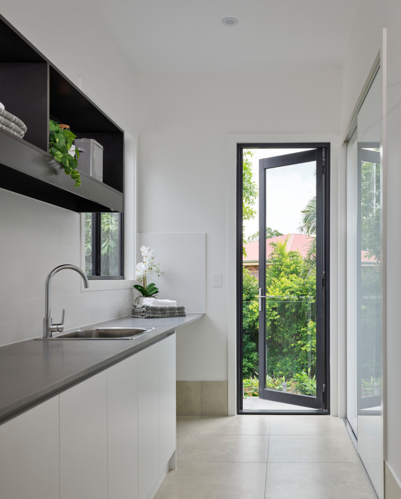 This is an example of a contemporary laundry room in Brisbane with ceramic floors.