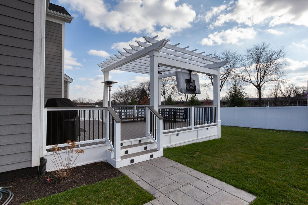 Inspiration for a large beach style backyard and ground level deck in Chicago with a fire feature, a pergola and mixed railing.