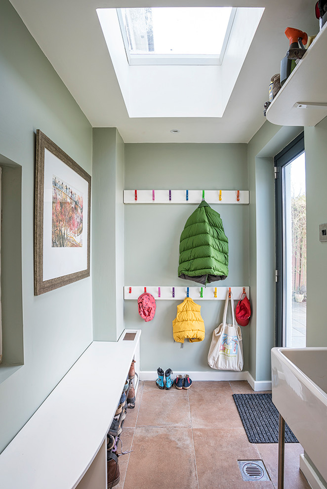 Photo of a mid-sized contemporary mudroom in Glasgow with green walls, terra-cotta floors and orange floor.