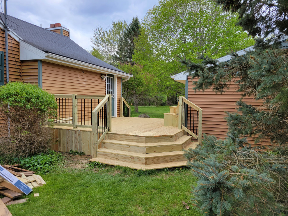 Inspiration for a side yard ground level mixed material railing deck remodel with no cover