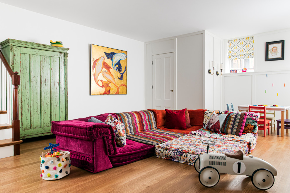 Example of a mid-sized eclectic gender-neutral light wood floor playroom design in Boston with white walls
