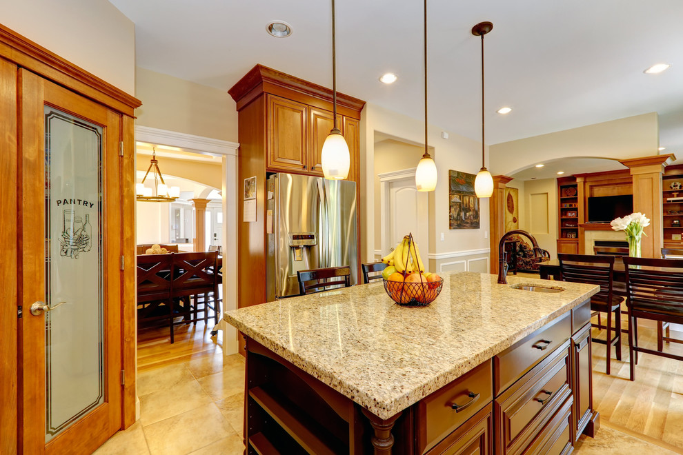 Eat-in kitchen - large transitional medium tone wood floor eat-in kitchen idea in Dallas with an undermount sink, raised-panel cabinets, dark wood cabinets, granite countertops and an island