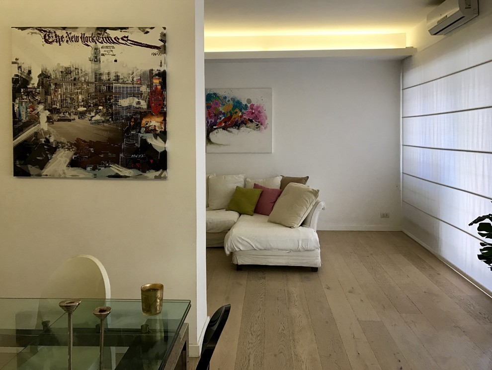 Foto di un grande soggiorno contemporaneo aperto con pareti bianche, parquet chiaro, cornice del camino in intonaco e TV a parete
