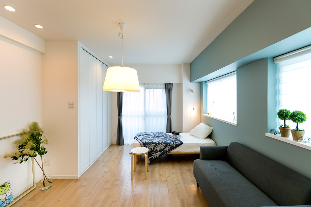 他の地域にある北欧スタイルのおしゃれな寝室 (青い壁、淡色無垢フローリング、ベージュの床) のインテリア