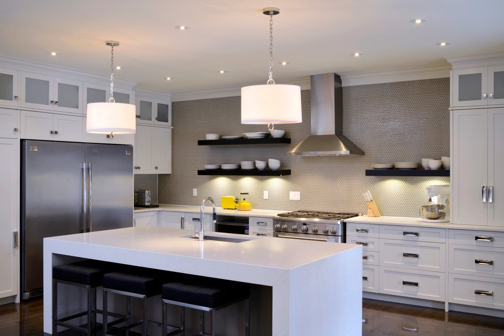 Design ideas for a contemporary l-shaped kitchen in Ottawa with an undermount sink, shaker cabinets, white cabinets, beige splashback, mosaic tile splashback and stainless steel appliances.