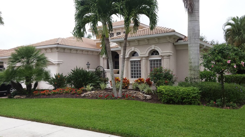 Photo of a mid-sized traditional one-storey stucco grey exterior in Miami with a hip roof.