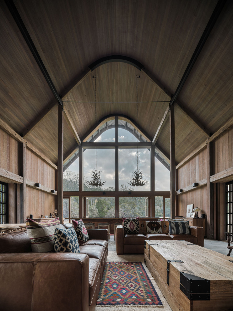 Design ideas for a mid-sized country open concept living room in Brisbane with slate floors, a standard fireplace, a stone fireplace surround, grey floor and brown walls.
