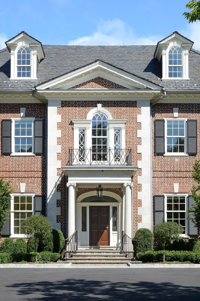 Design ideas for a large traditional three-storey brick red exterior in Other.