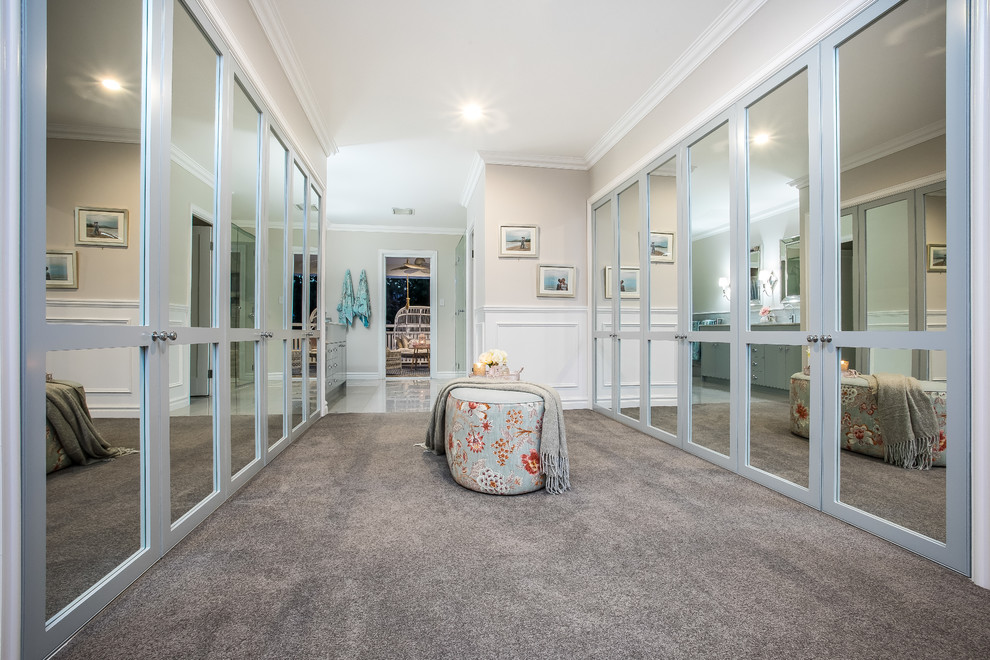 Photo of a large traditional gender-neutral dressing room in Brisbane with shaker cabinets, blue cabinets, carpet and grey floor.
