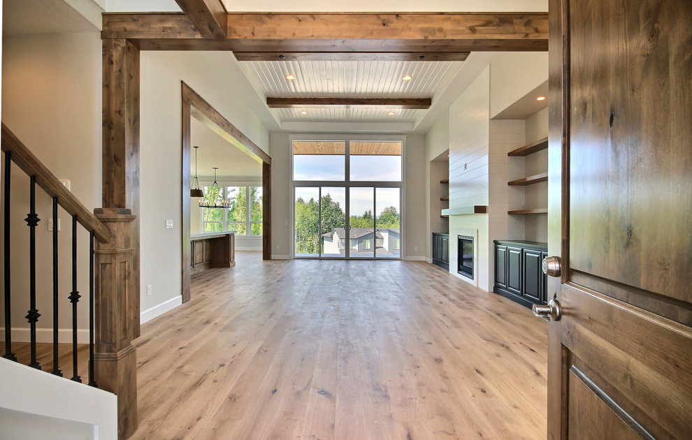 Inspiration for an expansive transitional foyer in Portland with beige walls, light hardwood floors, a single front door, a medium wood front door, brown floor and exposed beam.