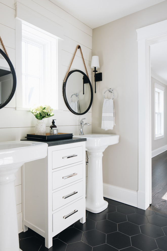 This is an example of a country bathroom in Chicago with flat-panel cabinets, white cabinets, grey walls, a pedestal sink, black floor and grey benchtops.