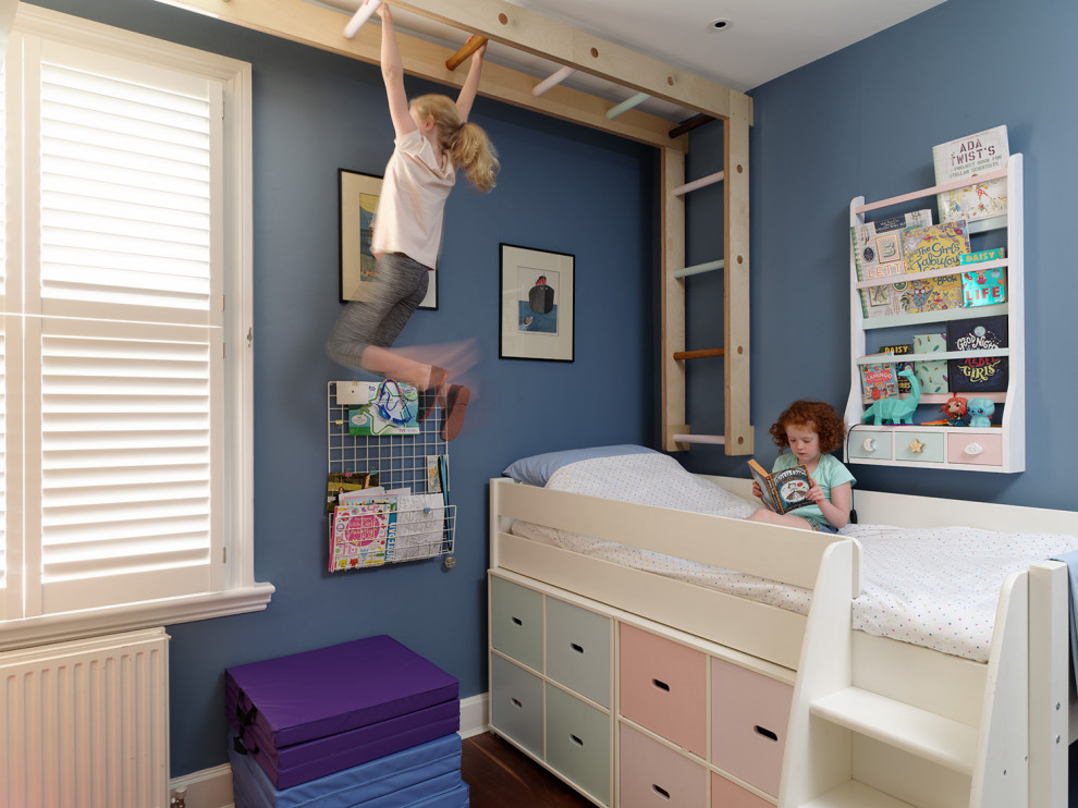 This is an example of a transitional kids' bedroom for kids 4-10 years old and girls in London with blue walls.