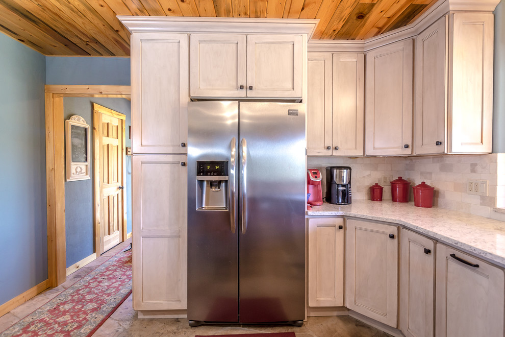 Inspiration for a mid-sized rustic l-shaped beige floor enclosed kitchen remodel in Denver with a farmhouse sink, medium tone wood cabinets, granite countertops, white backsplash, stainless steel appliances, an island and gray countertops