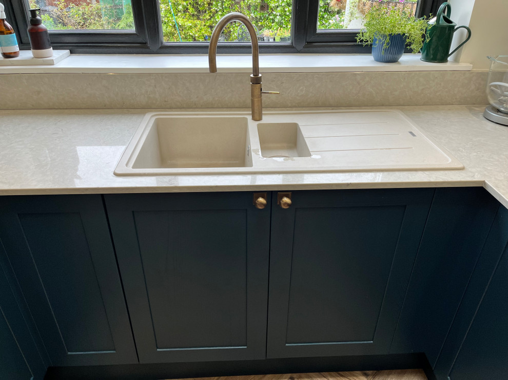 This is an example of a medium sized modern u-shaped open plan kitchen in Other with shaker cabinets, blue cabinets, quartz worktops, white splashback and white worktops.