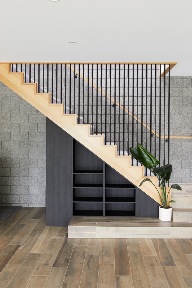 Foto de escalera en L contemporánea de tamaño medio con escalones enmoquetados, contrahuellas enmoquetadas, barandilla de madera y ladrillo