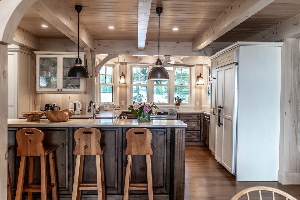 Mid-sized mountain style u-shaped light wood floor and beige floor eat-in kitchen photo with an undermount sink, raised-panel cabinets, distressed cabinets, quartz countertops, beige backsplash, wood backsplash, stainless steel appliances, an island and beige countertops