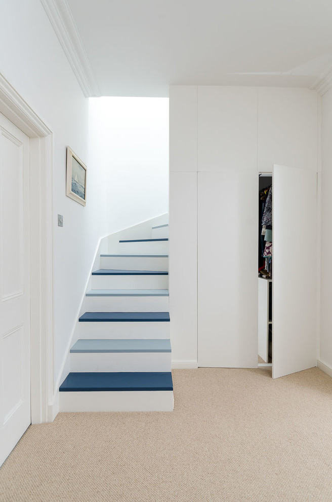 This is an example of a contemporary painted wood staircase in Other with painted wood risers.