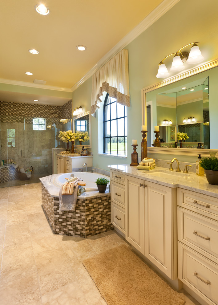 Photo of a large traditional master bathroom in Tampa with an undermount sink, raised-panel cabinets, beige cabinets, marble benchtops, a drop-in tub, an alcove shower, a two-piece toilet, multi-coloured tile, green walls and porcelain floors.