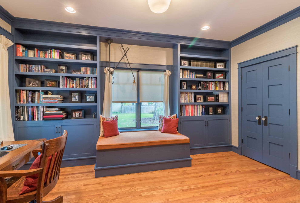 Photo of a mid-sized arts and crafts home office in Chicago with a library, white walls, light hardwood floors, no fireplace, a freestanding desk, brown floor, wallpaper and wallpaper.