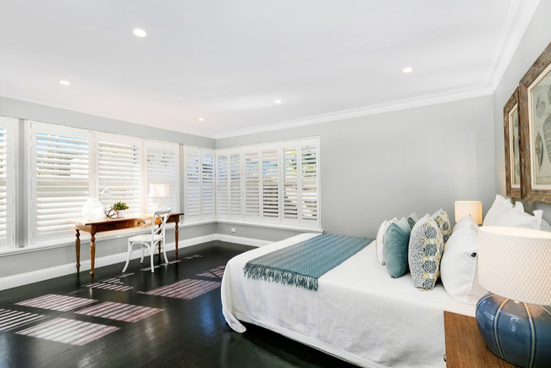 This is an example of a mid-sized contemporary bedroom in Sydney with grey walls, dark hardwood floors and brown floor.
