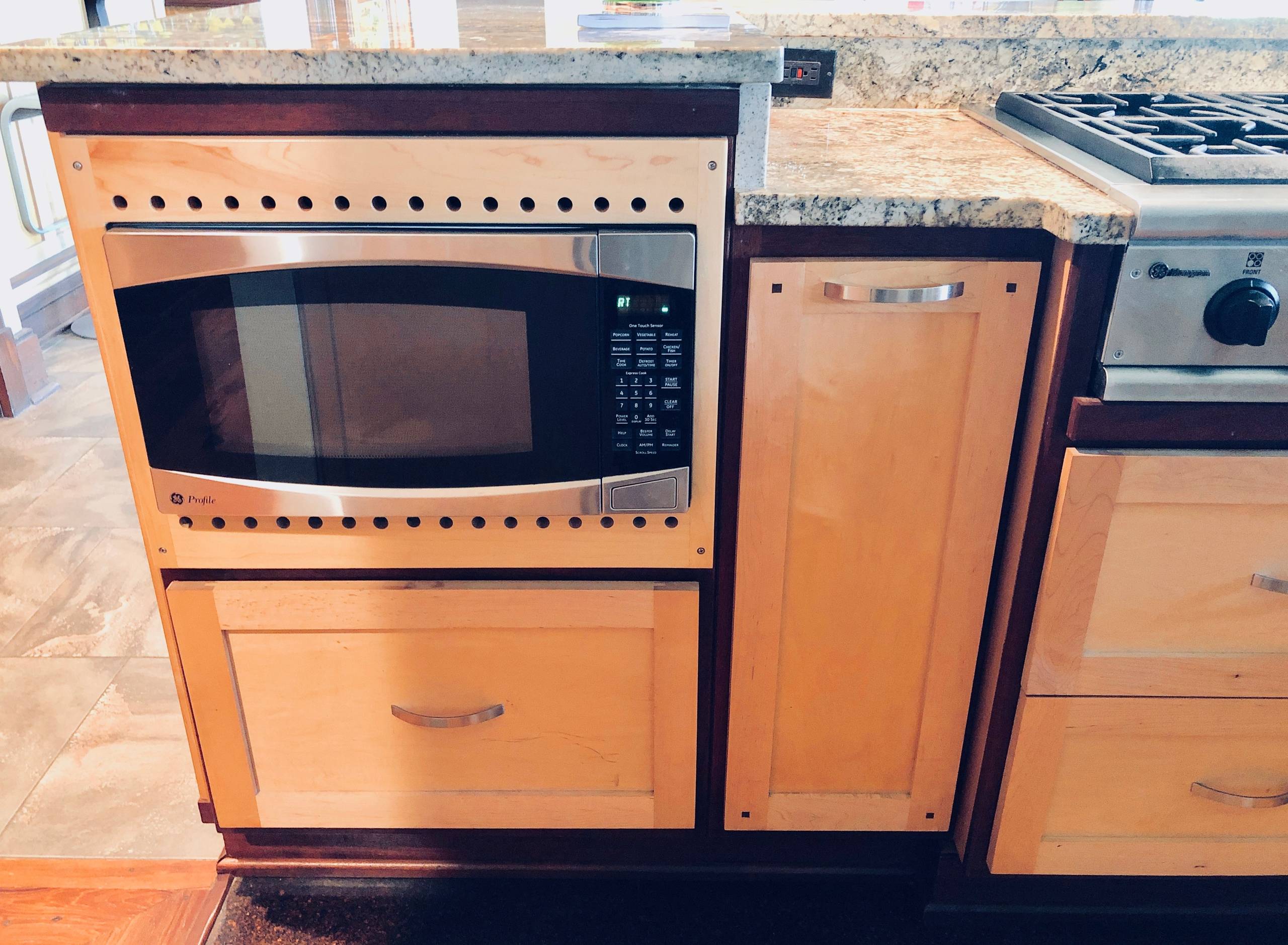 Custom cabinet for microwave with decorative design for ventilation