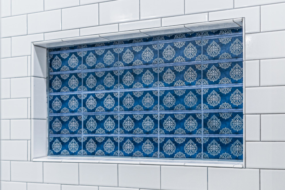 Inspiration för mellanstora klassiska flerfärgat en-suite badrum, med skåp i shakerstil, blå skåp, en dusch i en alkov, vit kakel, tunnelbanekakel, beige väggar, vinylgolv, ett undermonterad handfat, marmorbänkskiva, brunt golv och dusch med gångjärnsdörr