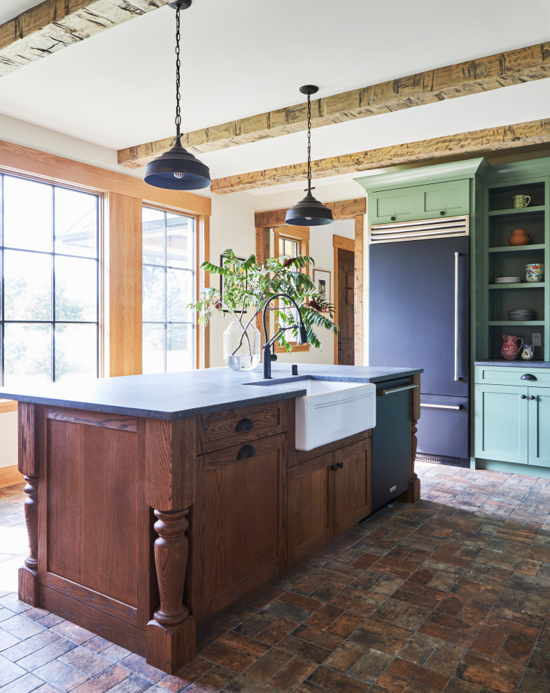 Inspiration for a mid-sized country l-shaped separate kitchen in Milwaukee with a farmhouse sink, shaker cabinets, green cabinets, quartz benchtops, grey splashback, engineered quartz splashback, black appliances, brick floors, with island, brown floor, grey benchtop and exposed beam.