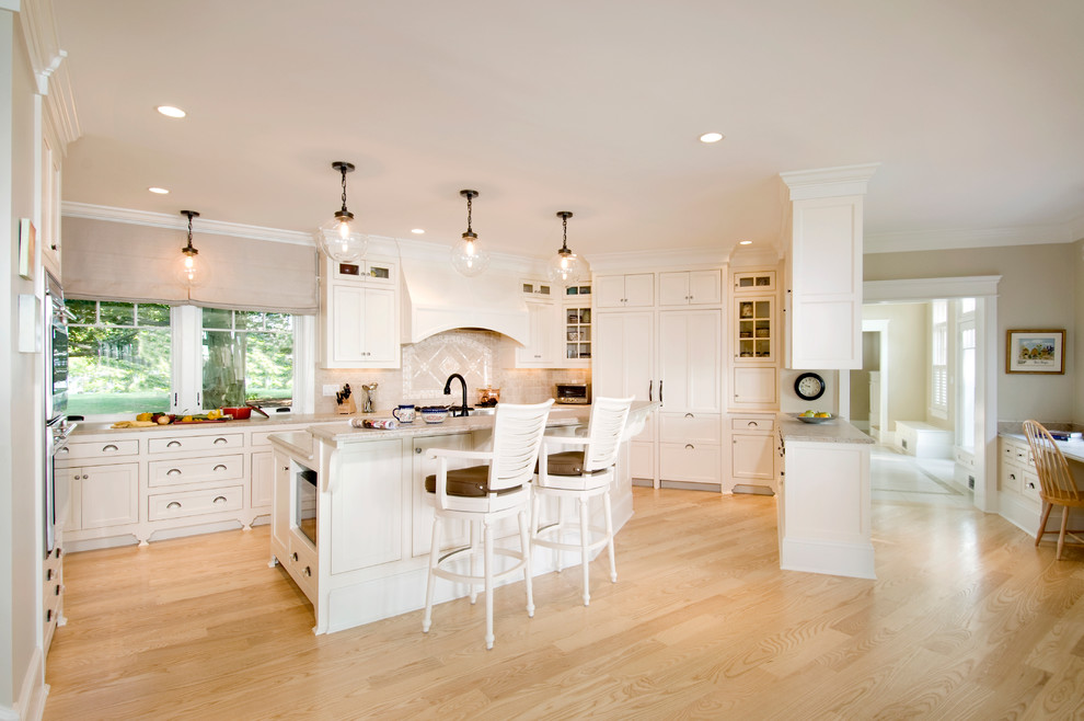 Photo of a traditional u-shaped kitchen in Boston with recessed-panel cabinets, white cabinets, beige splashback and panelled appliances.