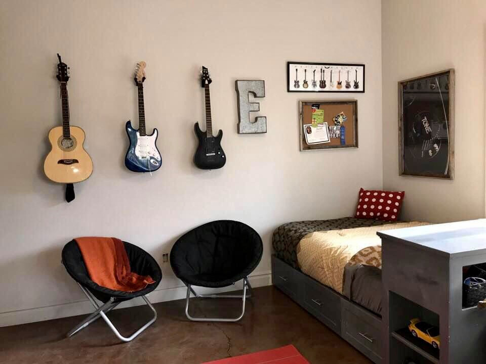 На фото: большая детская в классическом стиле с спальным местом, серыми стенами, бетонным полом и коричневым полом для подростка, мальчика