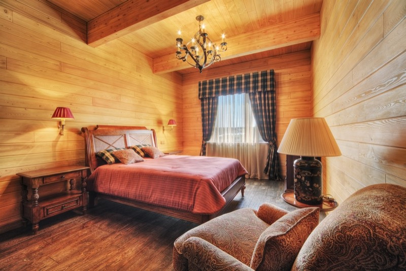 This is an example of a large transitional guest bedroom in Moscow with beige walls, medium hardwood floors and red floor.
