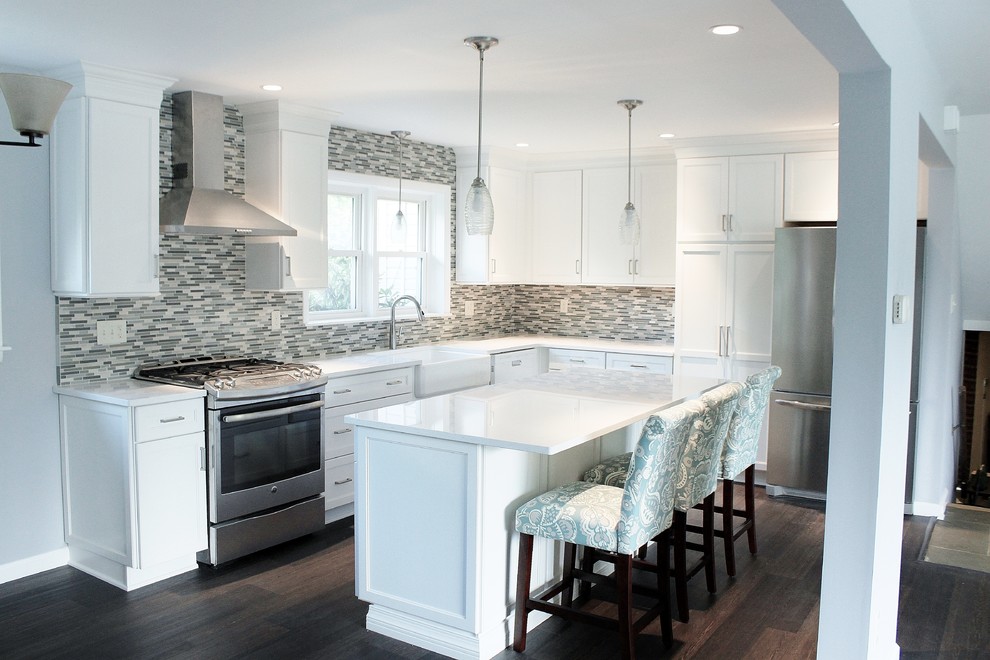 Photo of a mid-sized l-shaped eat-in kitchen in Philadelphia with a farmhouse sink, shaker cabinets, white cabinets, quartz benchtops, blue splashback, mosaic tile splashback, stainless steel appliances, vinyl floors, with island and brown floor.