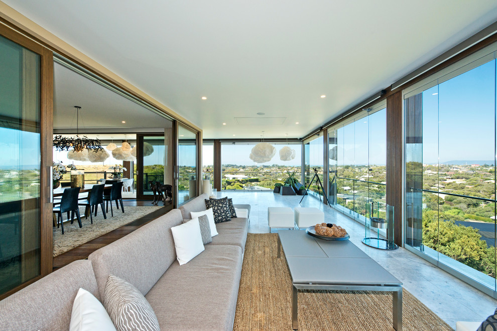 Inspiration for a contemporary balcony in Melbourne with a roof extension and glass railing.