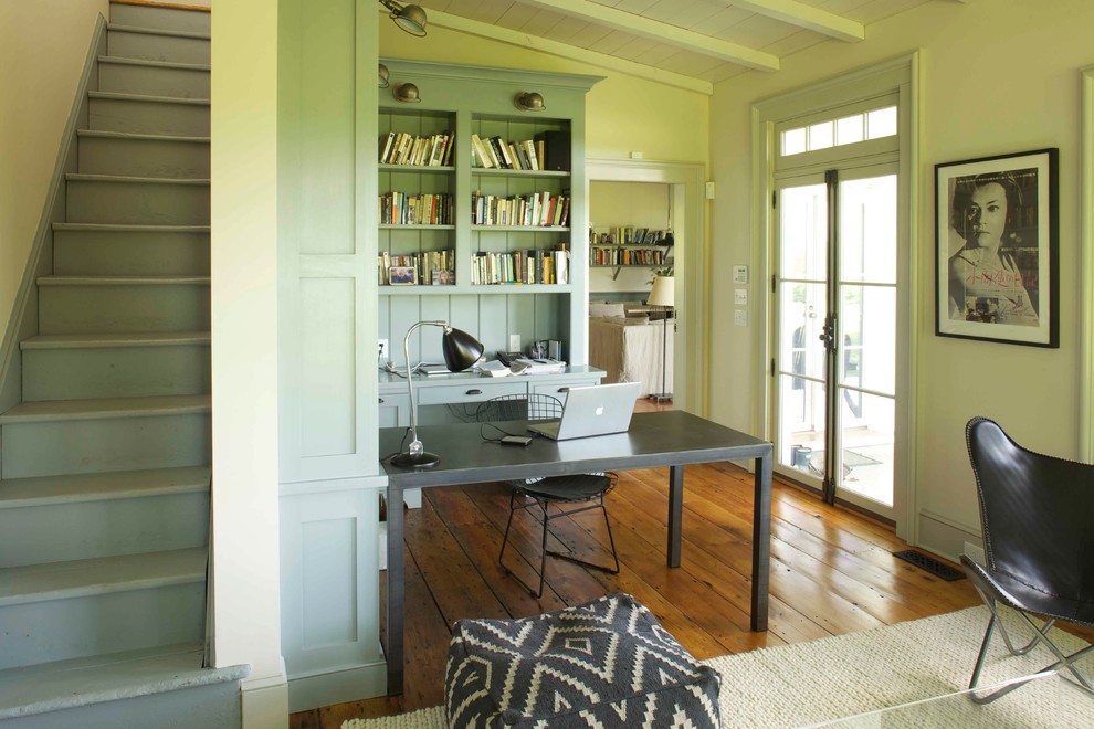 Photo of a country home office in Boston with green walls, medium hardwood floors, a freestanding desk and brown floor.