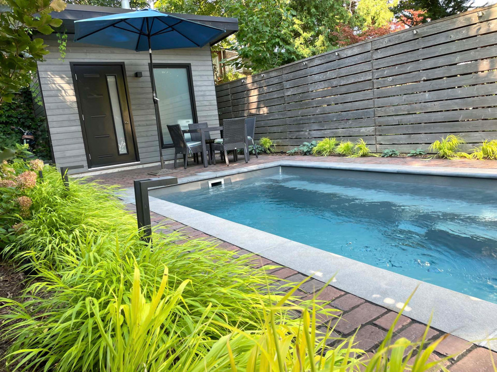 Design ideas for a mid-sized eclectic full sun backyard concrete paver and wood fence landscaping in Toronto.