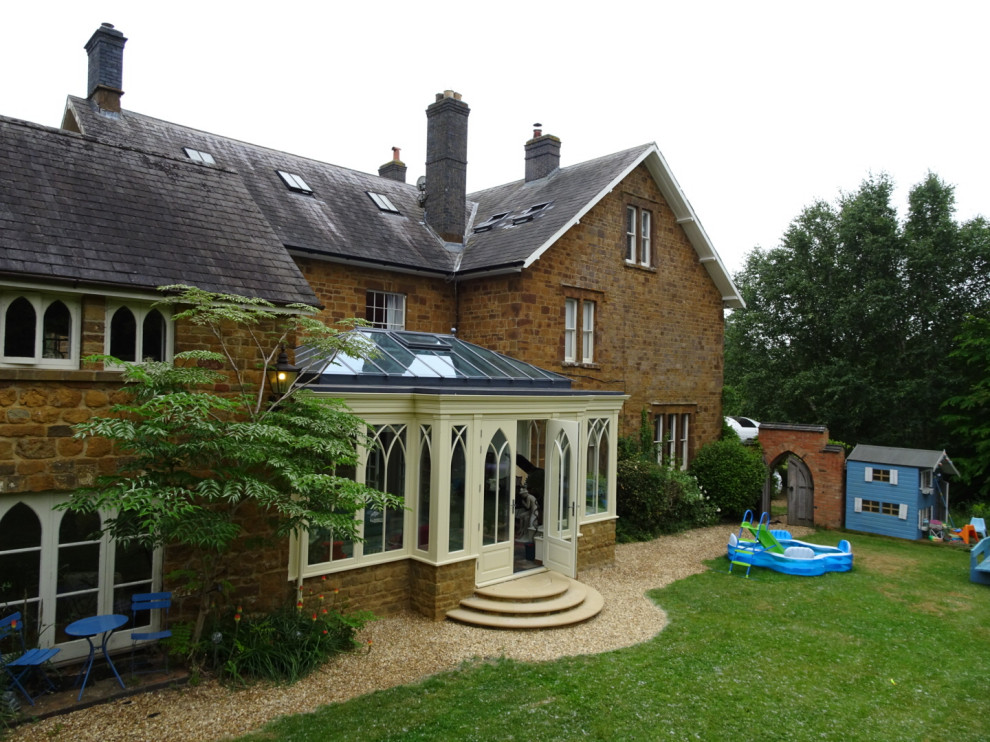 This is an example of a medium sized traditional conservatory in Oxfordshire with a glass ceiling and a feature wall.