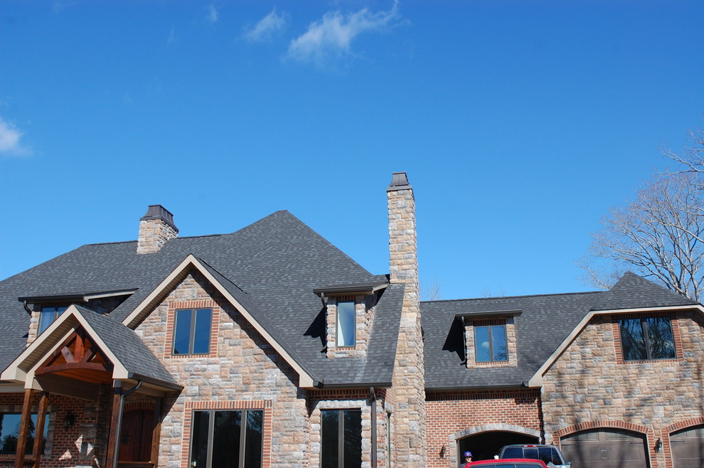 Example of a mountain style brown three-story brick exterior home design