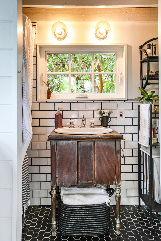 Country bathroom in Portland with dark wood cabinets, white tile, subway tile, white walls, a drop-in sink, wood benchtops, a shower curtain, brown benchtops, mosaic tile floors, black floor, a single vanity and a freestanding vanity.