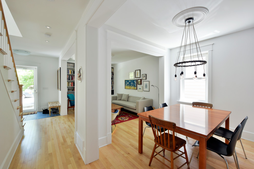 Small midcentury open plan dining in Ottawa with white walls and light hardwood floors.