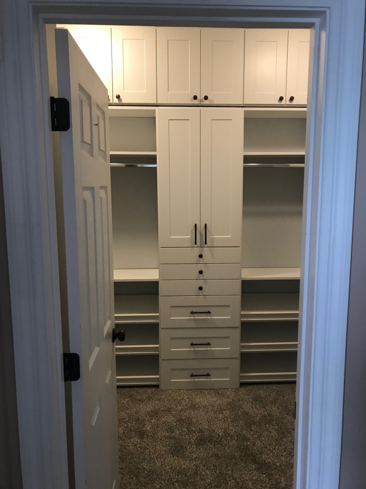 Mid-sized country gender-neutral walk-in wardrobe in St Louis with shaker cabinets, white cabinets, carpet and grey floor.