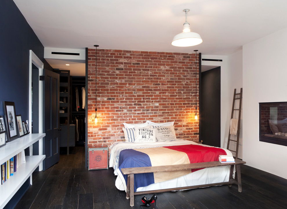 This is an example of a mid-sized industrial master bedroom in New York with blue walls and dark hardwood floors.