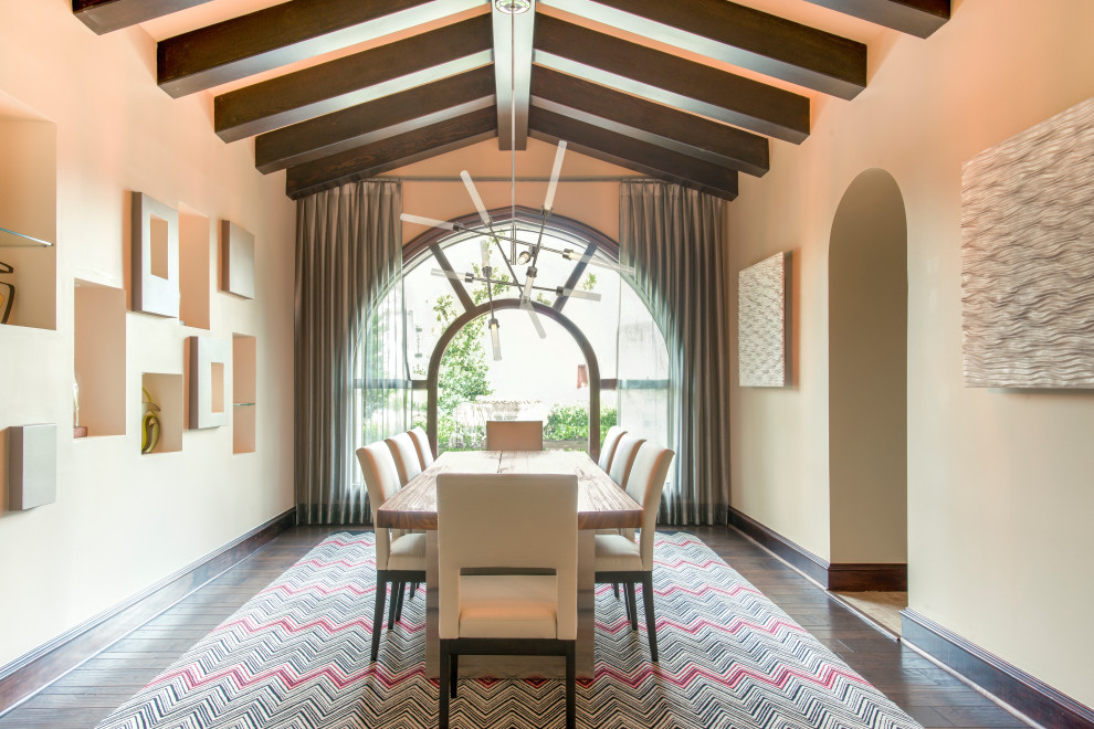 Large mediterranean separate dining room with beige walls, dark hardwood floors, exposed beam and brown floor.