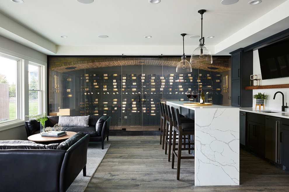 This is an example of an expansive modern wine cellar in Minneapolis with vinyl floors, display racks and black floor.