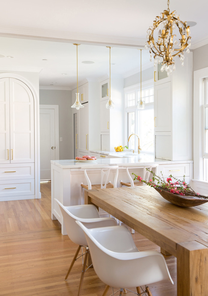 This is an example of a mid-sized scandinavian l-shaped eat-in kitchen in San Francisco with a farmhouse sink, recessed-panel cabinets, white cabinets, marble benchtops, marble splashback and medium hardwood floors.