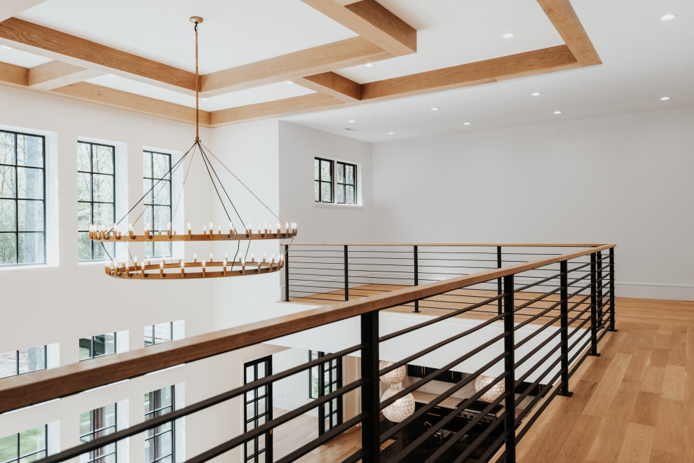 Hallway - mid-sized transitional light wood floor hallway idea with white walls