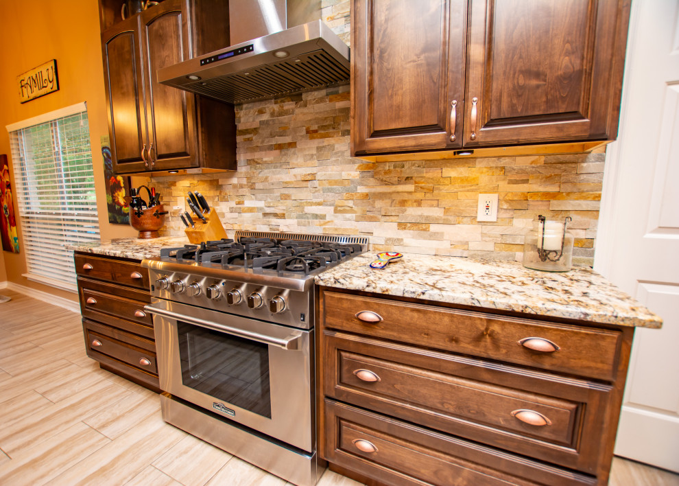 Kitchen - transitional porcelain tile and beige floor kitchen idea in Austin with a farmhouse sink, raised-panel cabinets, dark wood cabinets, granite countertops, stone tile backsplash, stainless steel appliances and an island