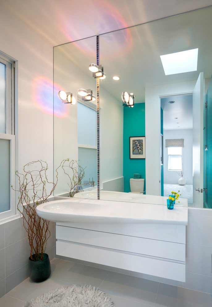 Contemporary bathroom in Los Angeles with an integrated sink, flat-panel cabinets, white cabinets and white walls.