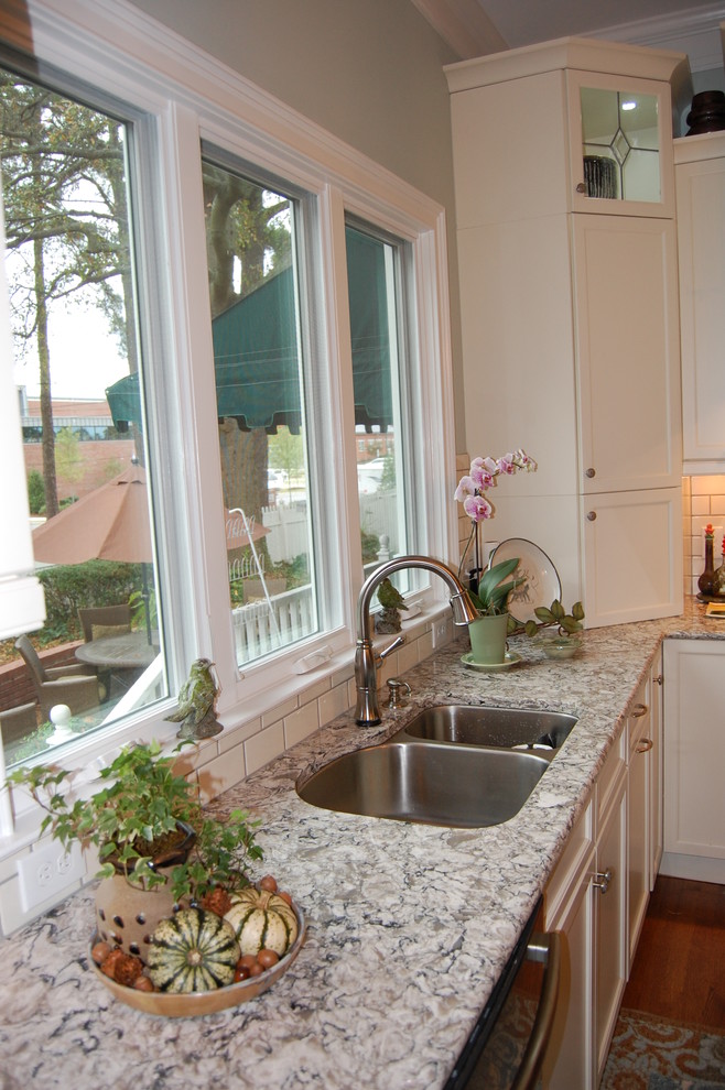 Inspiration for a transitional u-shaped eat-in kitchen remodel in Raleigh with an undermount sink, recessed-panel cabinets, white cabinets, quartzite countertops, white backsplash, subway tile backsplash and stainless steel appliances