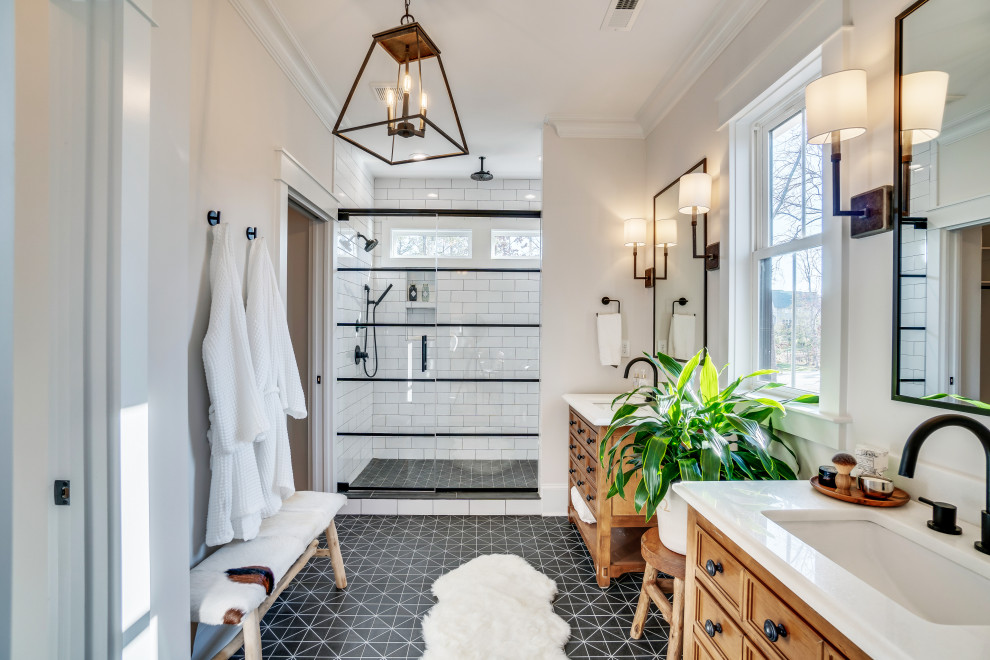 Design ideas for a country master bathroom in Richmond with furniture-like cabinets, medium wood cabinets, an alcove shower, white tile, white walls, cement tiles, engineered quartz benchtops, black floor, a hinged shower door and white benchtops.