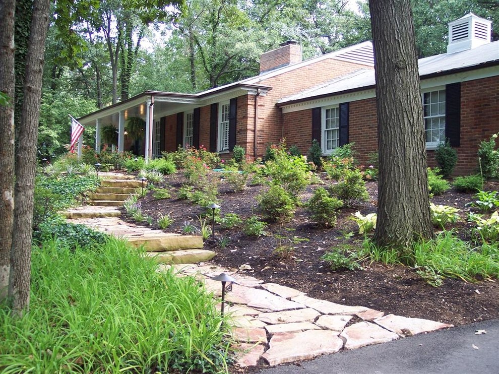Traditional side yard shaded formal garden in St Louis with a garden path and natural stone pavers for summer.