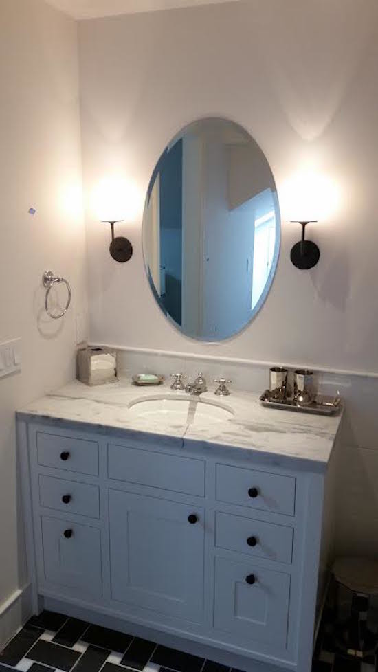 Small transitional 3/4 black floor bathroom photo in Denver with shaker cabinets, white cabinets, white walls, an undermount sink, marble countertops and gray countertops